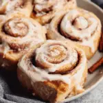 Banana bread cinnamon rolls with cream cheese frosting on plate