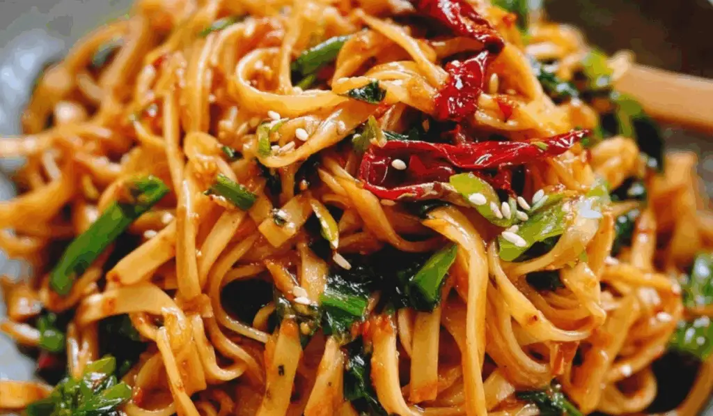 Chilli garlic noodles close-up with red chilies and scallions