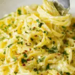 Creamy lemon pasta twirled on a fork with parsley garnish