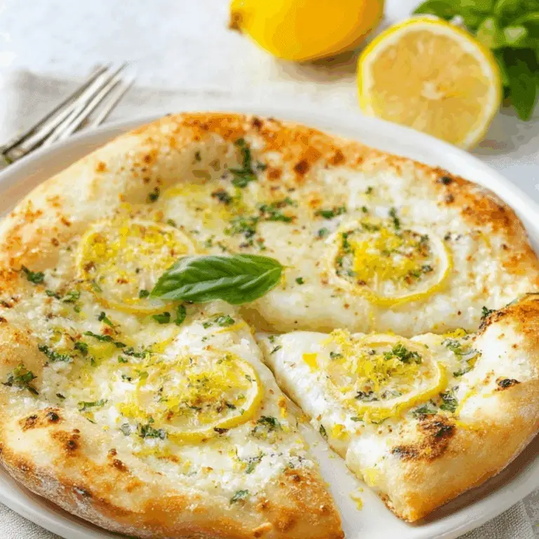 lemon pizza with white garlic sauce, herbs, and fresh lemon slices