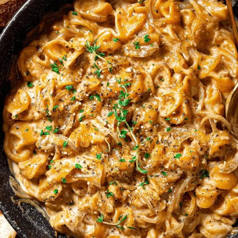 One pot French onion pasta with caramelized onions and creamy cheese sauce in a black skillet