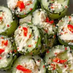Cucumber rolls filled with creamy salad and sprinkled with sesame seeds and red peppers