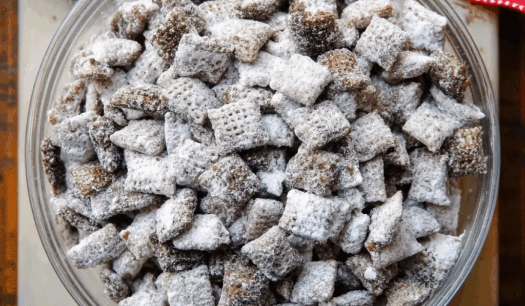 Puppy Chow Chex Mix in a bowl with powdered sugar
