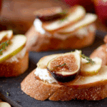 Brie, Apple, and Fig Crostini Appetizer served on a wooden tray