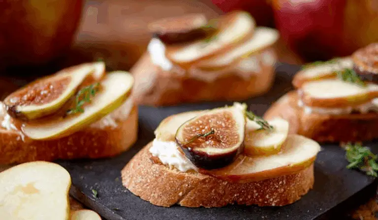 Brie, Apple, and Fig Crostini Appetizer served on a wooden tray
