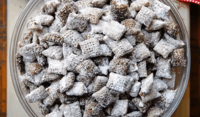 Puppy Chow Chex Mix in a bowl with powdered sugar