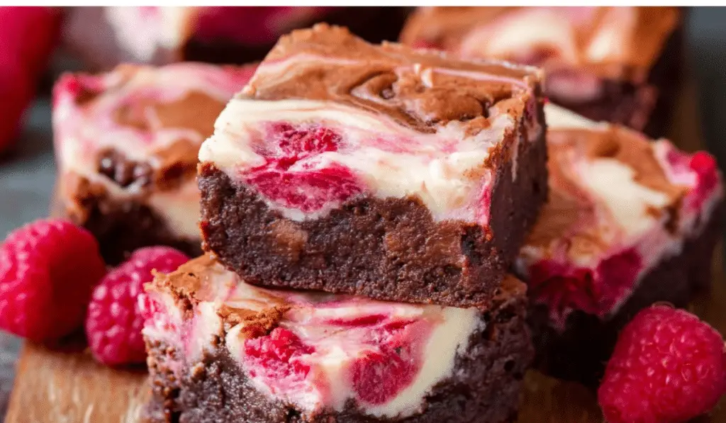 Raspberry Cheesecake Brownies stacked on a rustic table