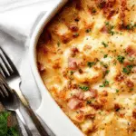 Cheesy Ham and Potato Casserole in a white baking dish
