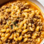 Bowl of homemade hamburger helper featuring macaroni and ground beef in a cheesy sauce.