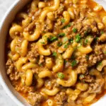Homemade Hamburger Helper served in a rustic bowl, garnished with fresh herbs.