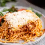 Delicious serving of Million Dollar Spaghetti casserole with layers of cheese and meat sauce.