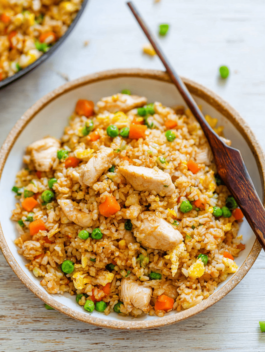 A colorful bowl of Better-Than-Takeout Chicken Fried Rice with green onions and chopsticks, showcasing the delicious ingredients.